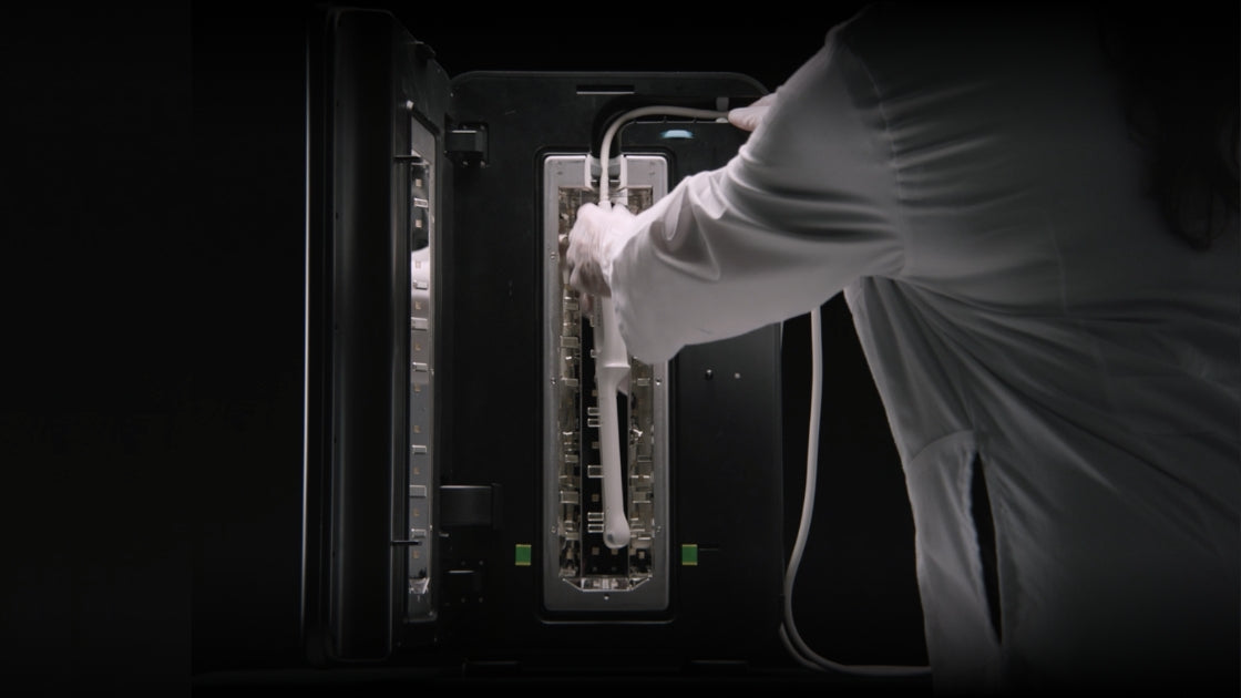 Praticien plaçant une sonde d'échographie dans l'enceinte de désinfection UV-C Lumicare ONE LITE