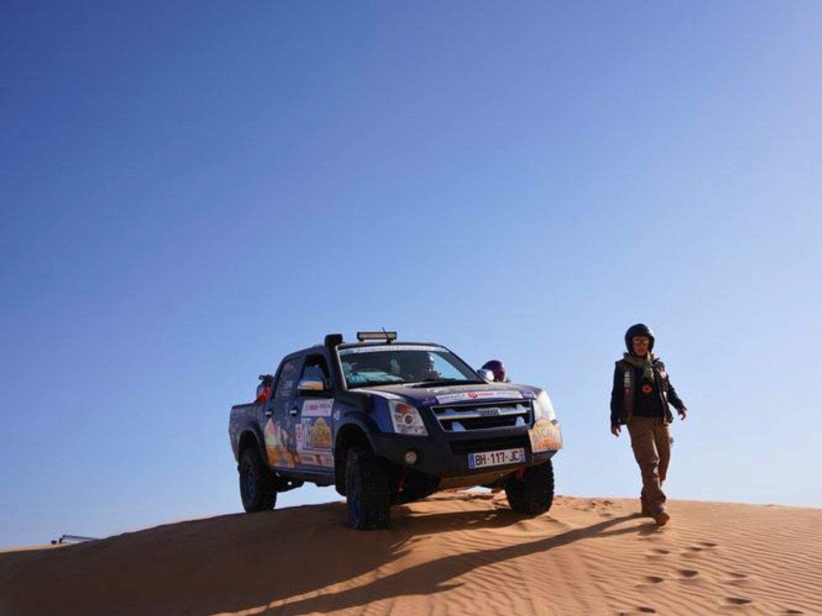 La voiture n°126 sur une crête de dune, équipière à pied
