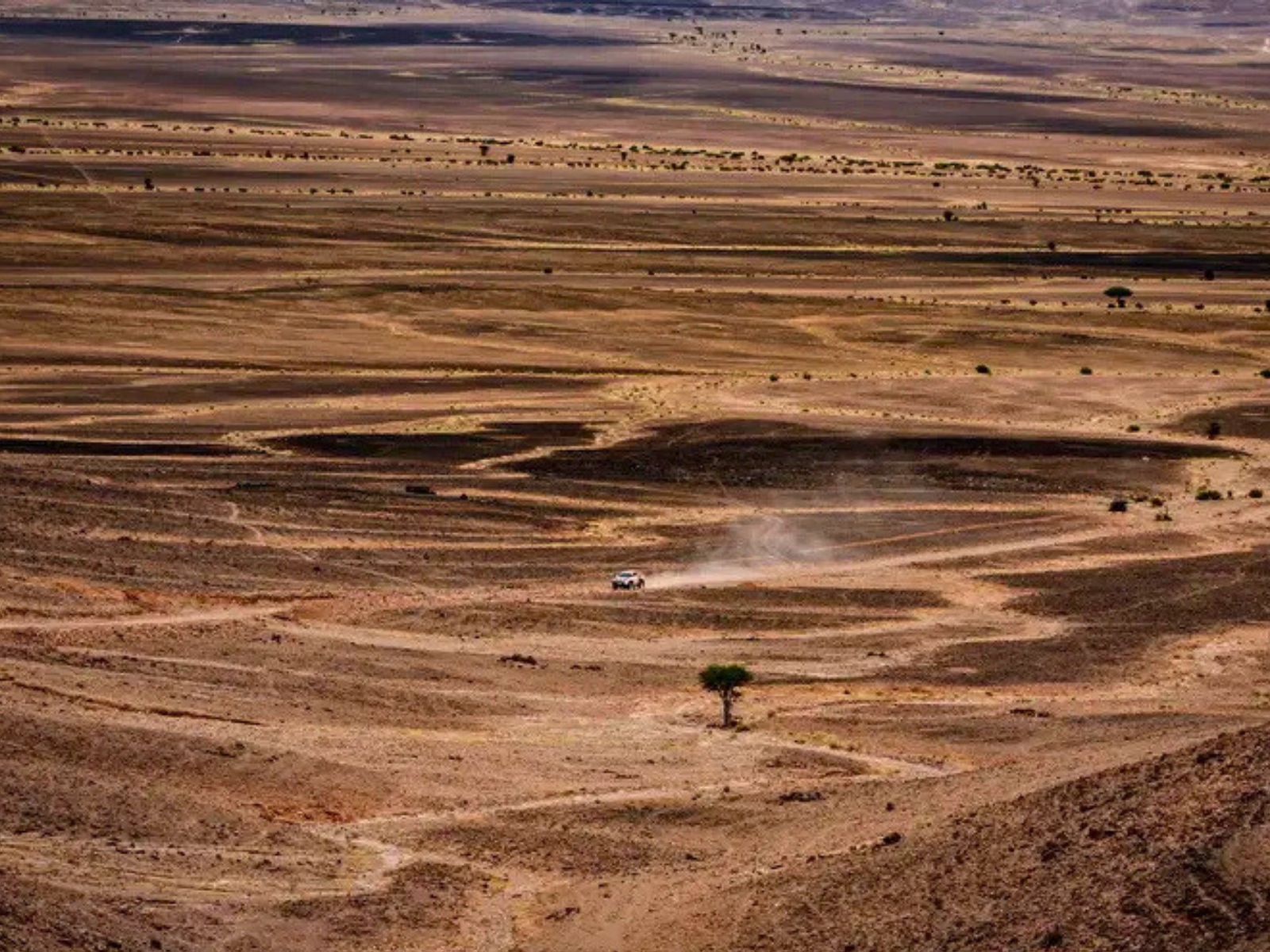 Vue aérienne — la voiture n°126, seule au monde dans l'immensité du désert marocain